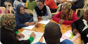 Adults working together around a table at a workshop