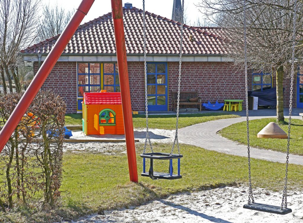 A preschool playground with swings and outdoor play equipment